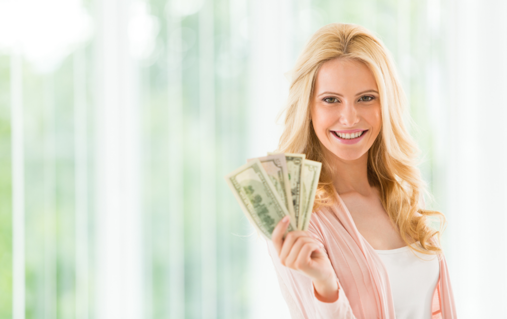 Smiling Woman Holding Out A "Fan" Of Money in Her Hand
