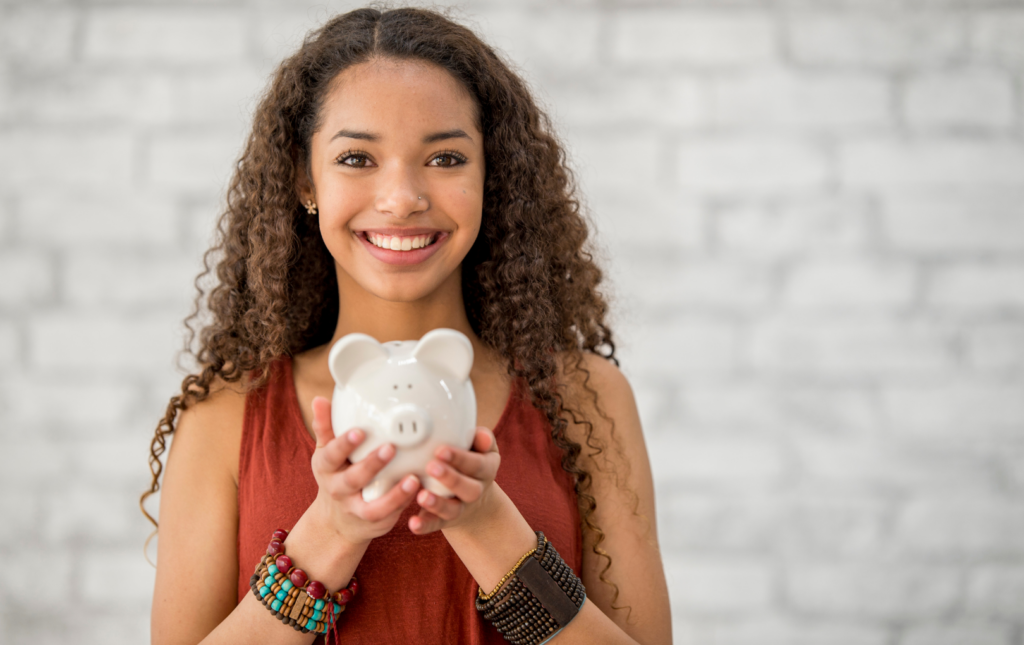 Smiling woman with a piggy bank in hand. women overcome financial challenges