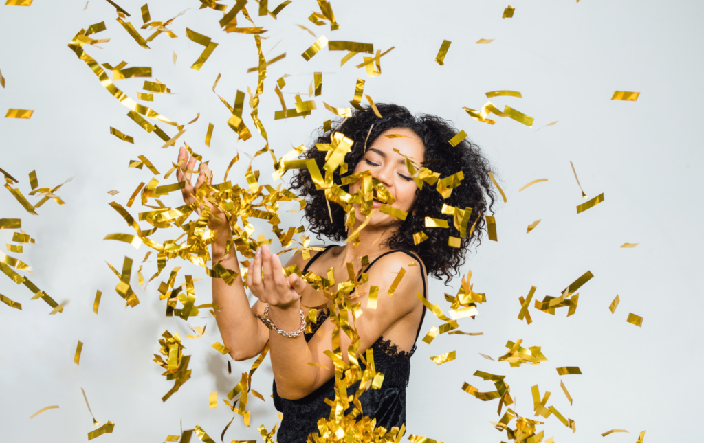 woman celebrating her financial wins with gold confetti