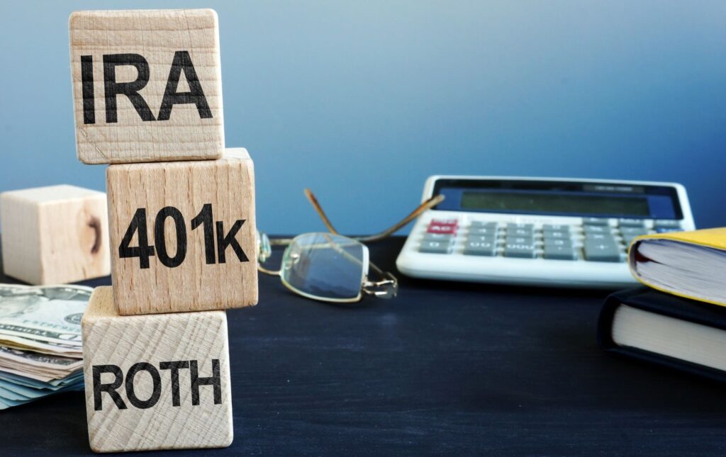 A calculator alongside three blocks piled on top of one another stating the following from the bottom up:ROTH, 410k and IRA. These are ways to increase the likelihood of being able to answer the question Will I Have Enough To Retire in the affirmative.