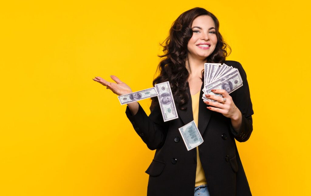 A young woman smiling and holding money representative of her empowering herself with her money and her former employer's 401k